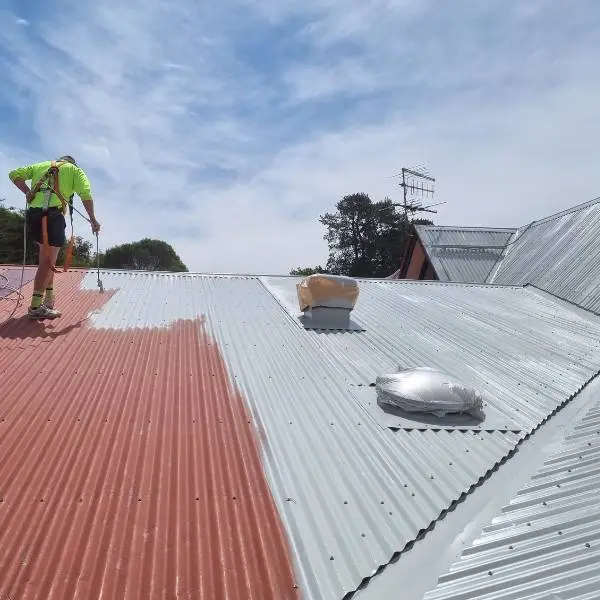 Spray-applying the membrane top coat over epoxy primer — Roof Restoration Services Northern Suburbs Melbourne